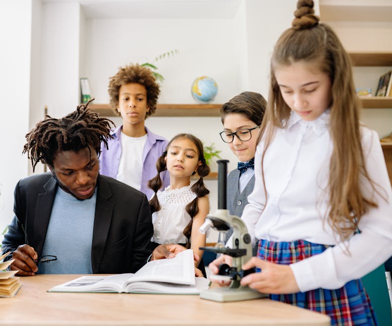 A teacher and students in a classroom engaging with a microscope for a science lesson